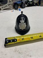Front view showing badge and measuring tape for scale