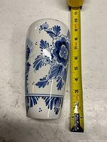 Side view with floral motif and tape measure showing height