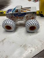 Side view of Blue Thunder monster truck showing body graphics and tire design
