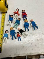 All eleven Playmobil figures laid out with ruler for scale