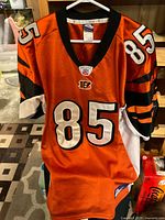 Front view of orange Cincinnati Bengals #85 jersey on hanger