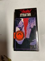 Front view of sealed Fatal Attraction VHS showing artwork, promo sticker and intact shrink-wrap