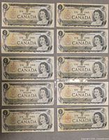 Front view of ten Canadian $1 bills laid out in two columns