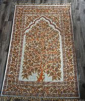 Full view of entire wall hanging laid flat showing design, fringe, overall condition