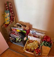 Overall view of lot: wrapping paper rolls, gift bags, bins with ribbons and decorations