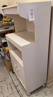 Full side view of white laminate kitchen cabinet on wheels