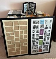 Lot overview with two large black collage frames and assorted frames/albums on table