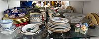 Full shelf view showing variety of bowls, plates, mini vases, basket and plaques