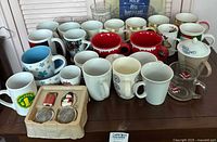overview of assorted mugs, glasses and infuser tray on table