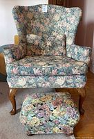 Front view of wingback armchair, ottoman visible
