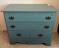 Front view of teal chest with closed drawers