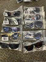 Ten pairs of sunglasses in sealed poly bags, top view