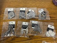 Eight sealed pairs of silver-tone dangle earrings on cards