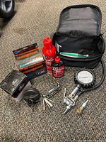 All items in lot laid out including tube box, gauge, lubricants, multi-tool and case