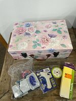 Closed floral suitcase-style box with craft items beside