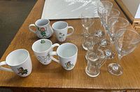 All 13 pieces displayed on table: five ceramic mugs, four wine goblets, three Irish Coffee glasses, one cordial stem