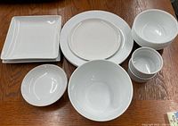 All 18 white dinnerware pieces arranged on table