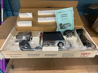 Open factory box showing transceiver, microphone, antenna assembly, manual, packaging