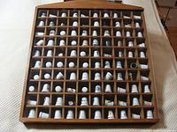 Full view of wooden display case filled with thimbles