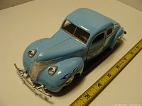 Front and left side view of blue 1940 Ford Coupe die-cast model with ruler showing scale