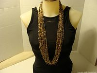 Full view of necklace on mannequin showing length and multi-strand design