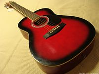Full view of red sunburst Jay Turser acoustic guitar