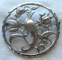 Front view of sterling silver brooch showing bird and floral design