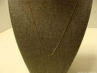 Full view of gold chain on display bust