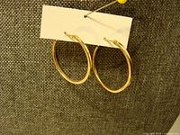 Both gold hoop earrings on card showing full view