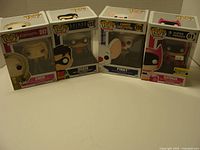 Front view of four boxed Funko Pop! figures: Cher, Robin, Pinky, Batman