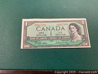 Front of 1954 Canada one dollar bill showing serial number, portrait of Queen Elizabeth II, denomination and bank text