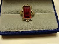 Ring front view showing rectangular red gemstone and white gold setting