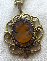 Front view of cameo pendant showing glass profile and filigree frame