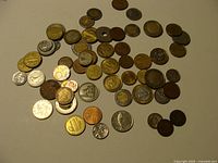 Scattered view of entire group of mixed world coins on light surface