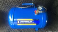 Full view of blue 5-gallon air tank showing handle, hose, valve and gauge