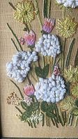Close-up of raised floral stitches and linen ground