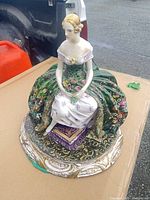 Full view of seated lady figurine on base