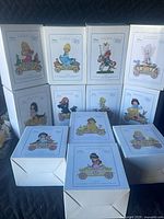 Stack of 12 boxed Disney Birthday Parade figurines