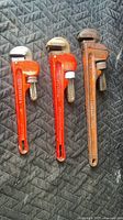 Three pipe wrenches side by side showing relative sizes and condition
