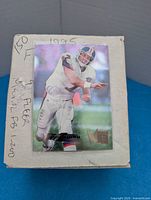 Top of card box showing sleeved 1995 Fleer Ultra John Elway card and handwritten note