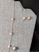 Closer view of pearls on chain and stud earrings