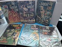 Six The Twilight Zone comic books arranged; three standing, three lying flat, all in plastic sleeves