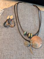 Necklace and earrings laid on fabric showing design and condition