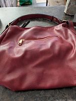 Smooth leather side with gold zipper pocket and strap detail