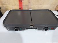 Front view of Hamilton Beach electric griddle showing cooking surface, control knobs, indicator light and brand name