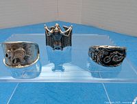 Front view of three novelty rings showing motorcycle, bat, elephant designs