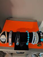 All six bracelets displayed on black stand