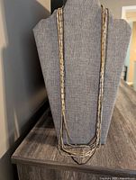 Front view of mixed metal multi-strand necklace on display bust