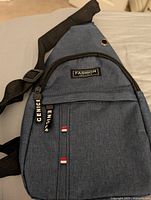 Front view showing logo patch, zippers, strap attachment