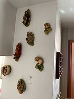 Seven wall-mounted Bossum Pottery animal plaques displayed together